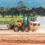 yellow and black front loader on brown soil during daytime